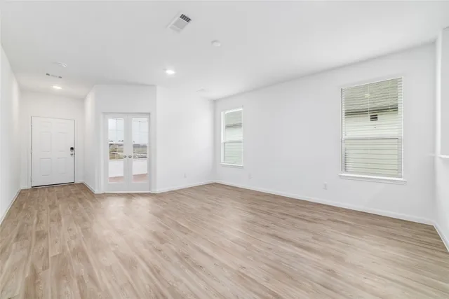 a view of empty room with wooden floor and window