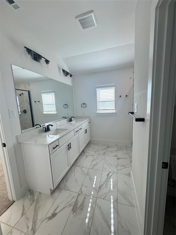 1313 Eureka Spgs Street Prosper, TX 75078 - Photo 14 of 40 Bathroom with double vanity, light marble finish flooring, a marble finish shower, and vaulted ceiling