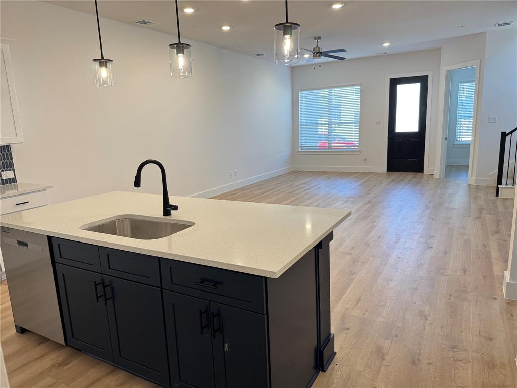 1313 Eureka Spgs Street Prosper, TX 75078 - Photo 40 of 40 Kitchen with light wood-type flooring, hanging light fixtures, dishwasher, open floor plan, and an island with sink