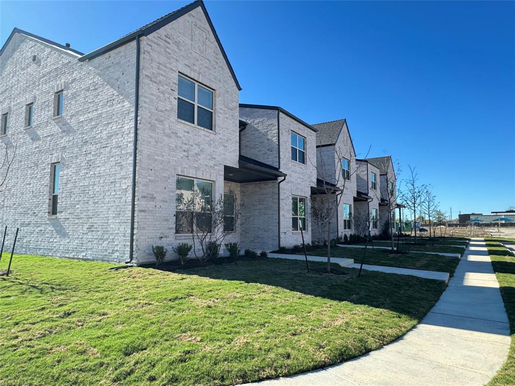 1313 Eureka Spgs Street Prosper, TX 75078 - Photo 21 of 40 View of home's exterior featuring brick siding, a lawn, and a residential view