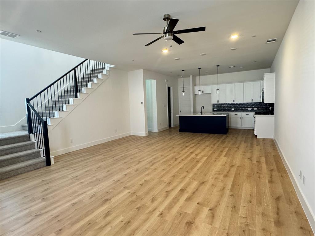 1313 Eureka Spgs Street Prosper, TX 75078 - Photo 29 of 40 Unfurnished living room with stairway, light wood finished floors, and a ceiling fan