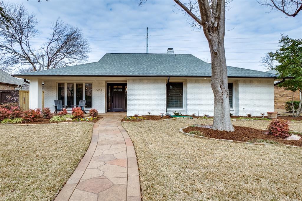 a view of a house with backyard and trees