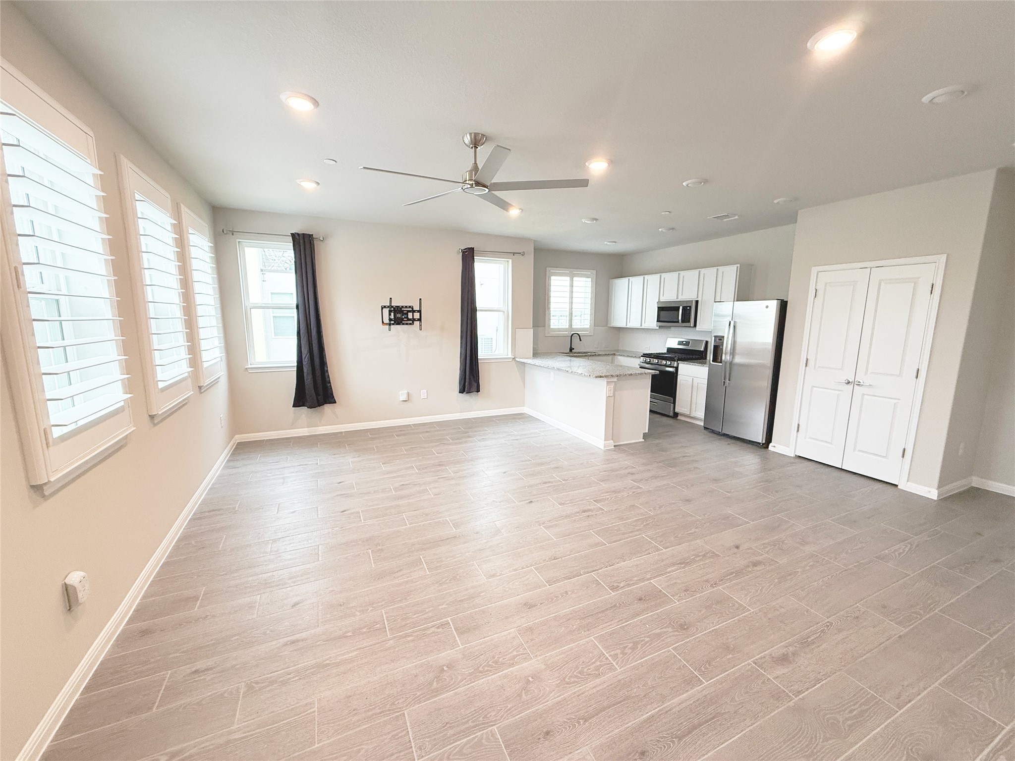 9015 Cattle Baron Path, Unit 605 Austin, TX 78747 - Photo 20 of 20 Kitchen and living room featuring recess light, appliances with stainless steel finishes, open floor plan, and ceiling fan