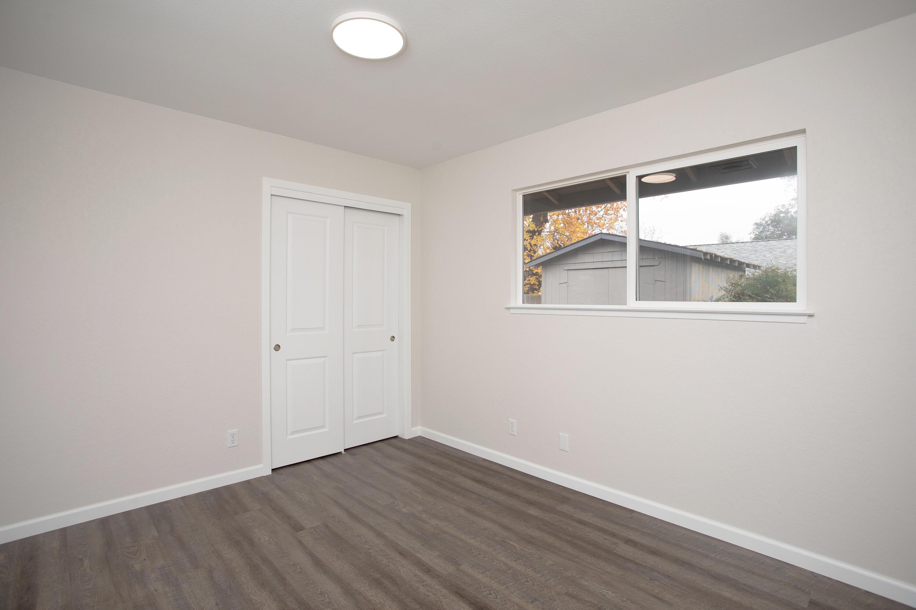 3693 Echo Road Redding, CA 96002 - Photo 18 of 30 an empty room with wooden floor and windows