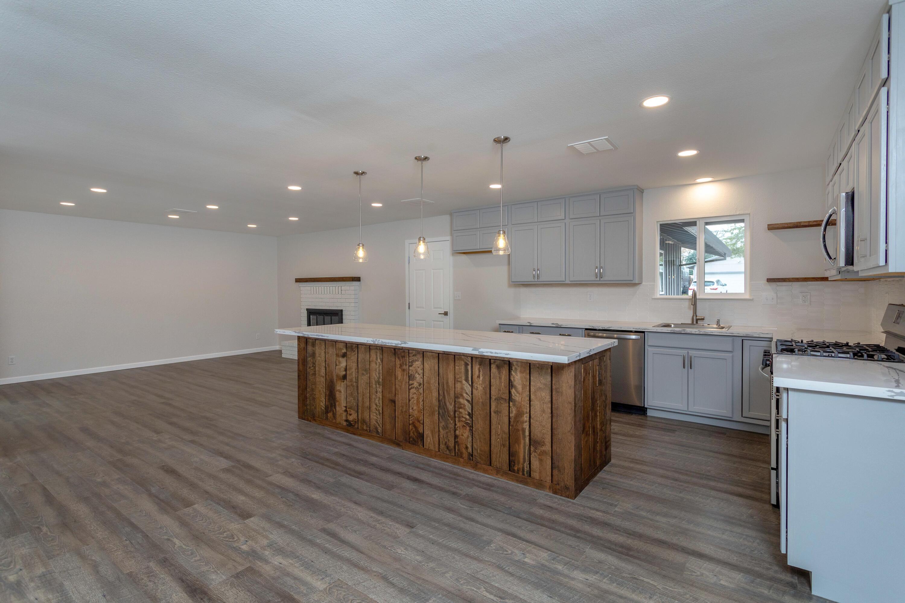 3693 Echo Road Redding, CA 96002 - Photo 4 of 30 a large kitchen with a center island wooden floor stainless steel appliances and cabinets