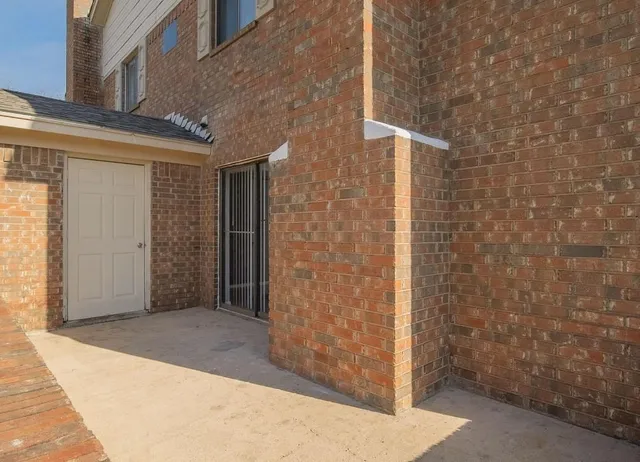 a view of a brick house with a large parking space