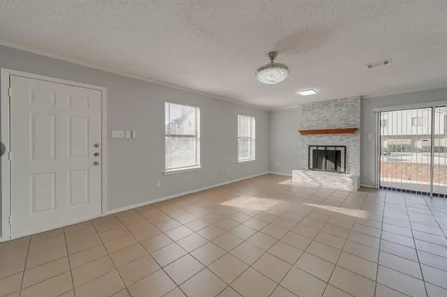an empty room with windows and fireplace