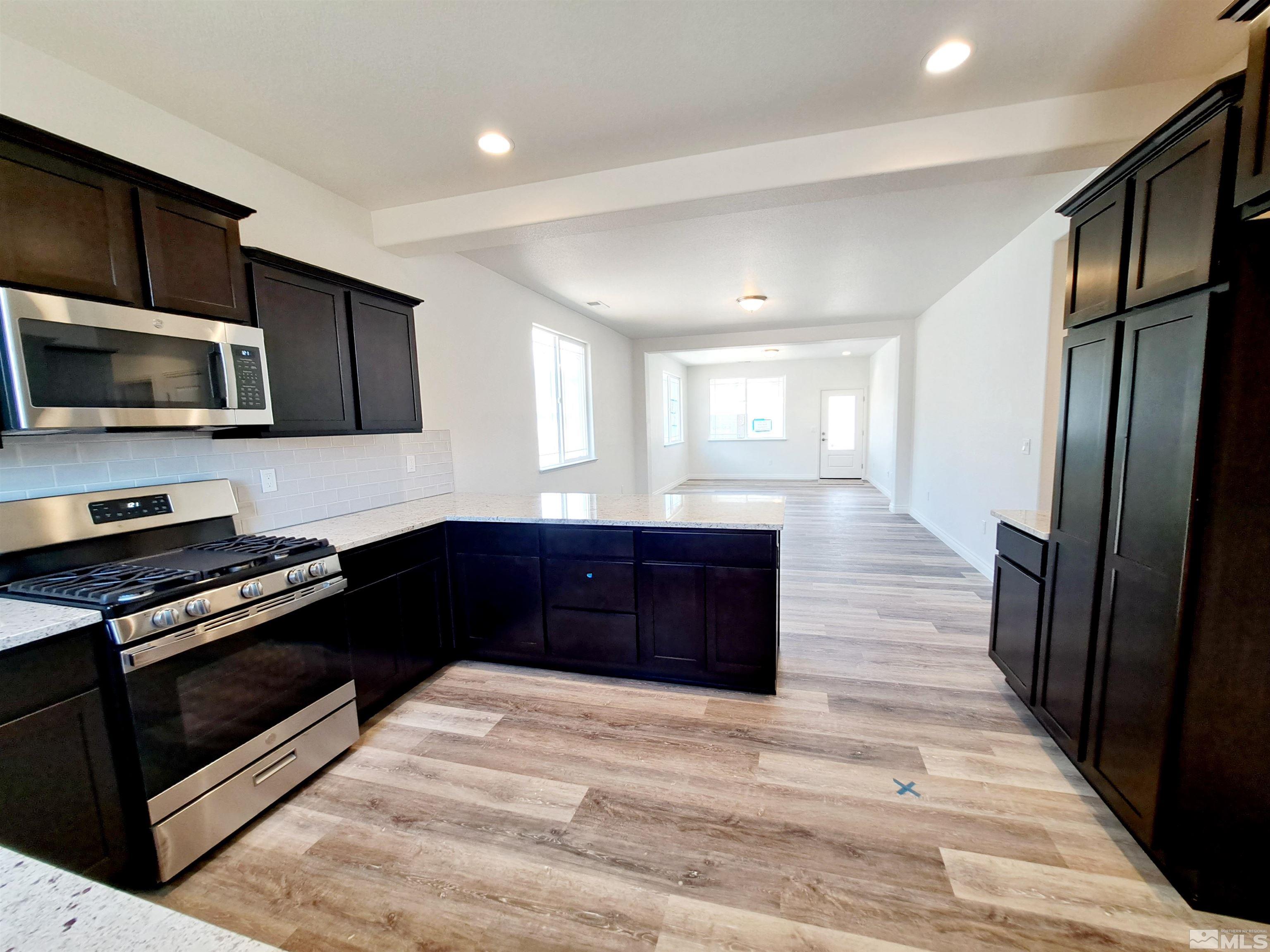 19013 Alpine Walk Court, Unit LOT 1881 Reno, NV 89508 - Photo 4 of 26 a kitchen with granite countertop wooden cabinets and stainless steel appliances