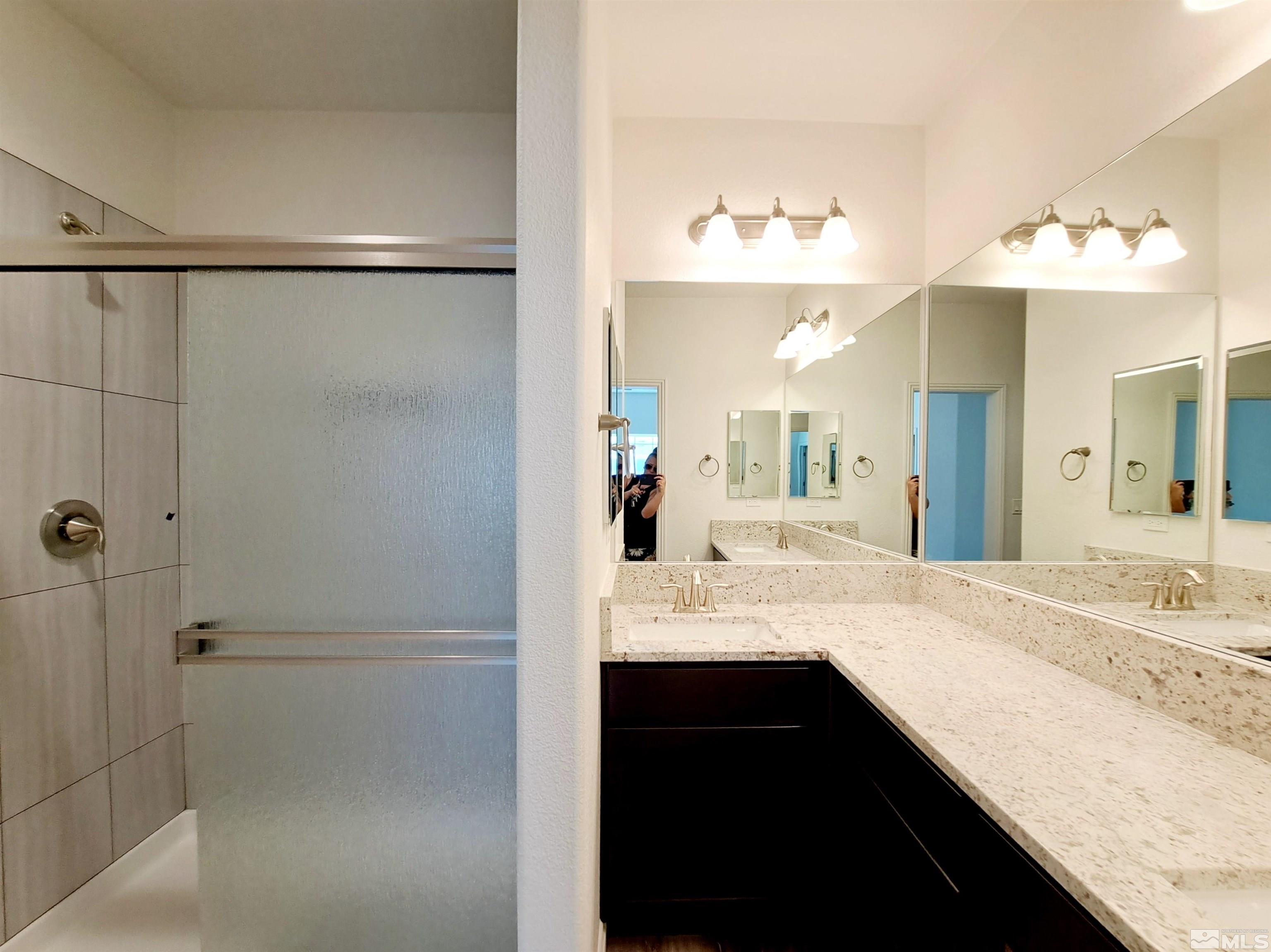 19013 Alpine Walk Court, Unit LOT 1881 Reno, NV 89508 - Photo 6 of 26 a bathroom with a granite countertop sink mirror and a