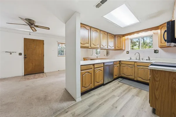 a kitchen with a sink cabinets stainless steel appliances and a window