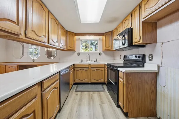 a kitchen with stainless steel appliances granite countertop a sink and dishwasher a stove top oven with wooden floor