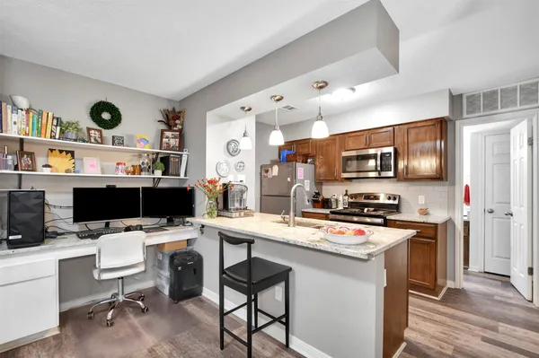 a kitchen that has a microwave a stove and white cabinets