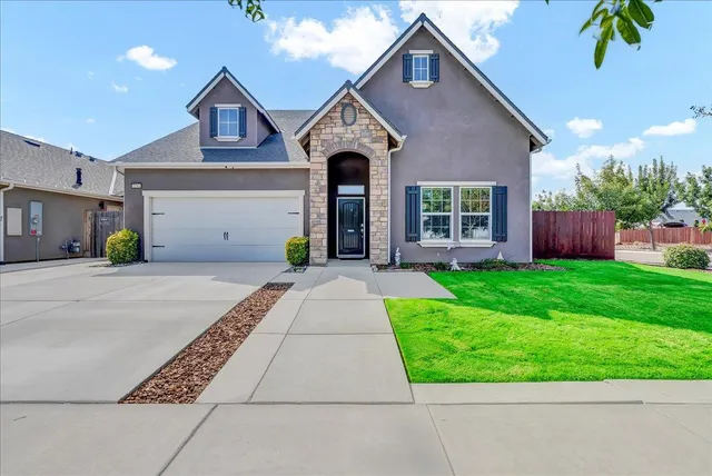 a front view of a house with a yard and garage