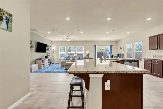 a large kitchen with stainless steel appliances granite countertop a table and chairs