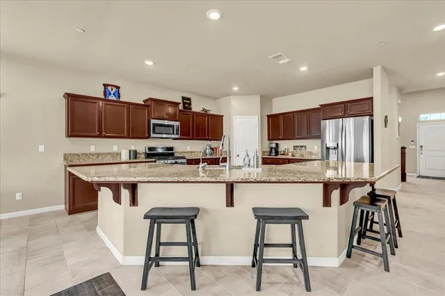 a kitchen with stainless steel appliances granite countertop a refrigerator stove and sink