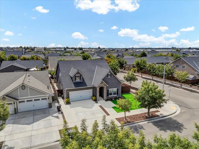 an aerial view of a house with a garden and lake view