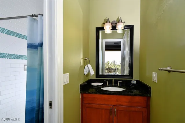 a bathroom with a granite countertop sink and a mirror