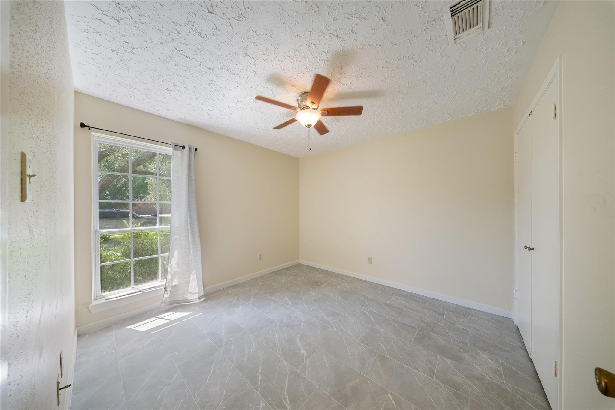 15738 Tammany Lane Houston, TX 77082 - Photo 13 of 22 an empty room with a window and a ceiling fan