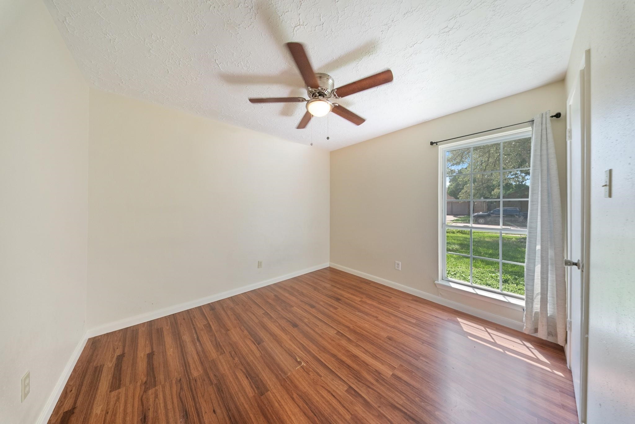 15738 Tammany Lane Houston, TX 77082 - Photo 14 of 22 wooden floor in an empty room with a window