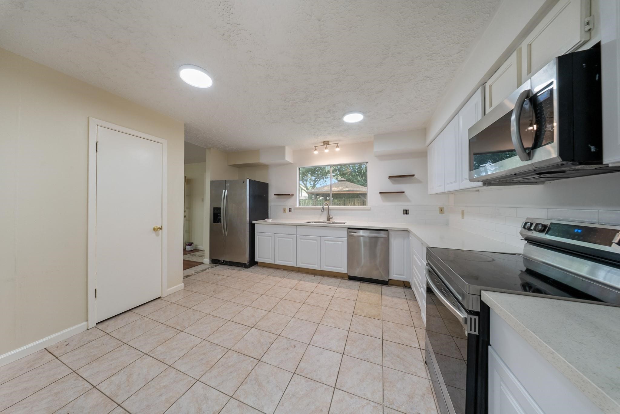 15738 Tammany Lane Houston, TX 77082 - Photo 21 of 22 a kitchen with a sink a stove and refrigerator