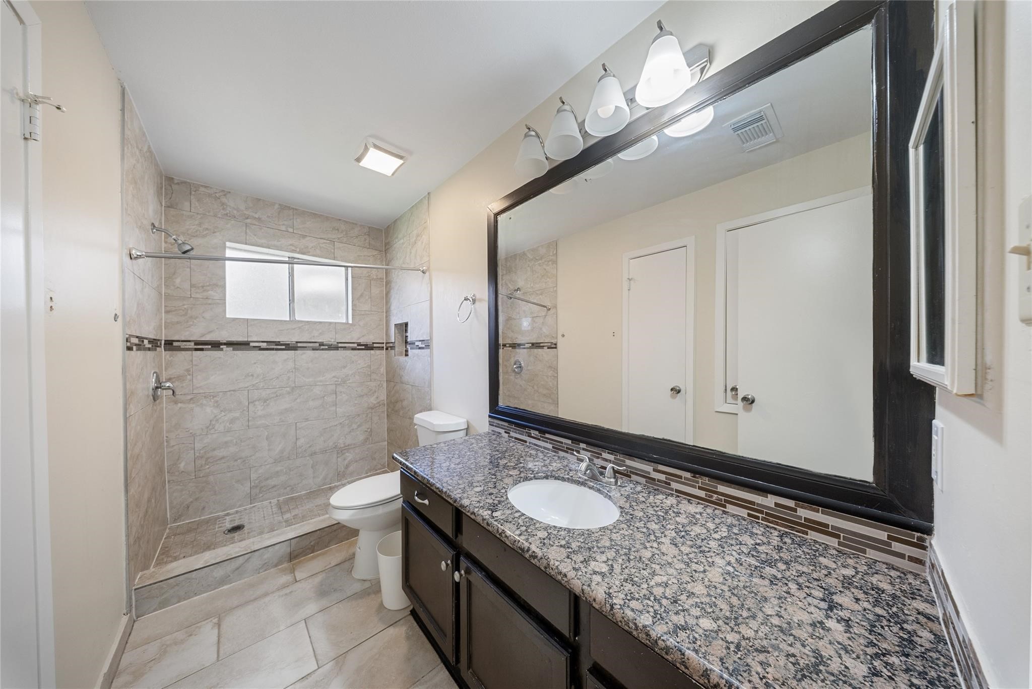 15738 Tammany Lane Houston, TX 77082 - Photo 5 of 22 a bathroom with a granite countertop sink and a mirror