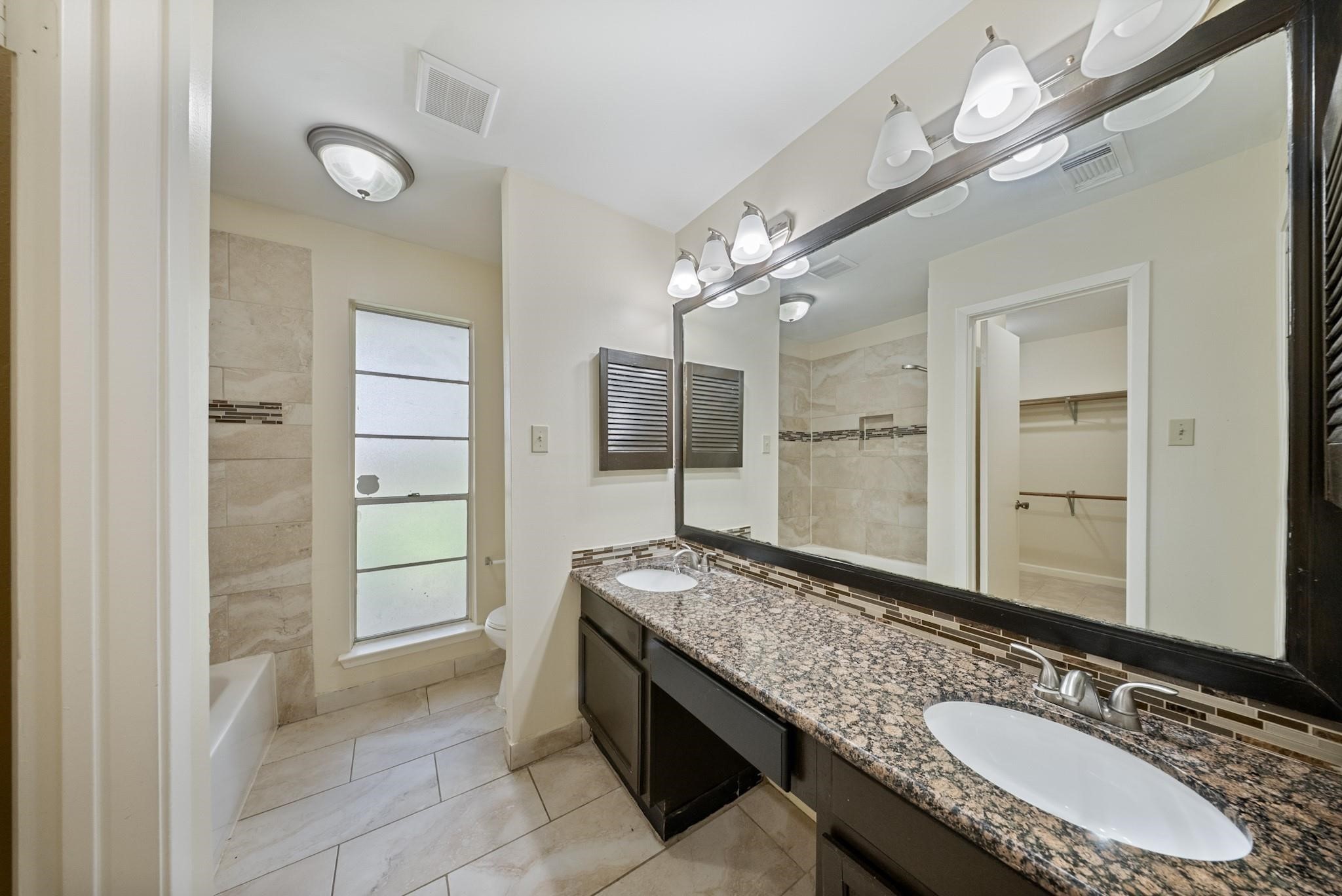 15738 Tammany Lane Houston, TX 77082 - Photo 9 of 22 a bathroom with a granite countertop double vanity sink and a mirror