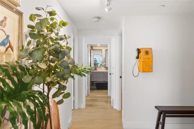 a dining room with furniture a potted plant and a floor to ceiling window