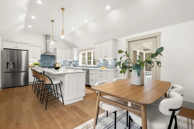 a kitchen with a table chairs refrigerator and microwave