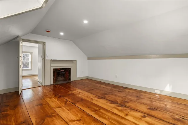 a view of empty room with wooden floor and fireplace