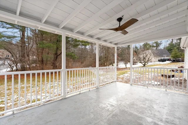 a view of a porch with wooden floor and roof with a garden view