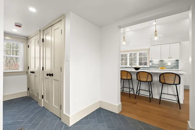 a kitchen with stainless steel appliances granite countertop a table chairs and a refrigerator