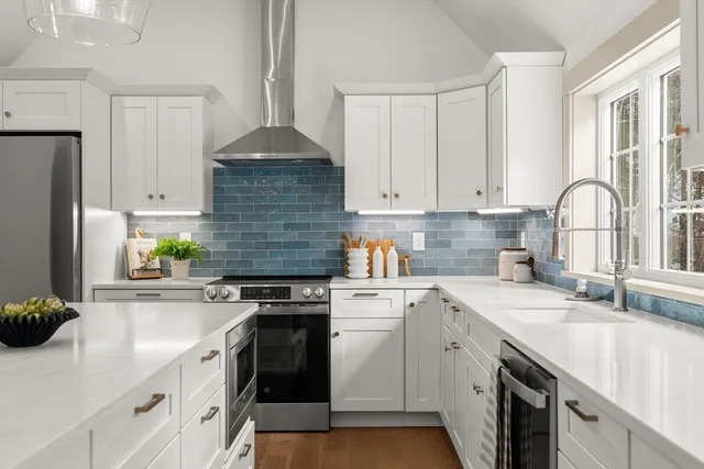 a kitchen with stainless steel appliances granite countertop a sink stove refrigerator and cabinets