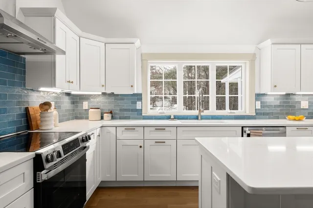 a kitchen with stainless steel appliances granite countertop a sink stove and cabinets