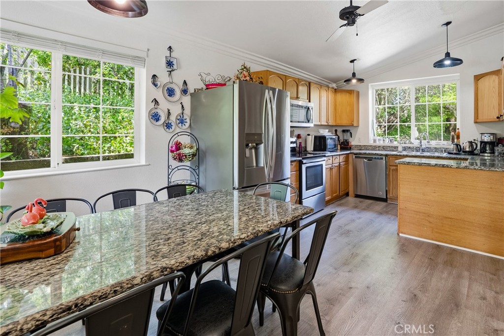 6701 East Zayante Road Felton, CA 95018 - Photo 13 of 44 a kitchen with granite countertop a table chairs stove and refrigerator