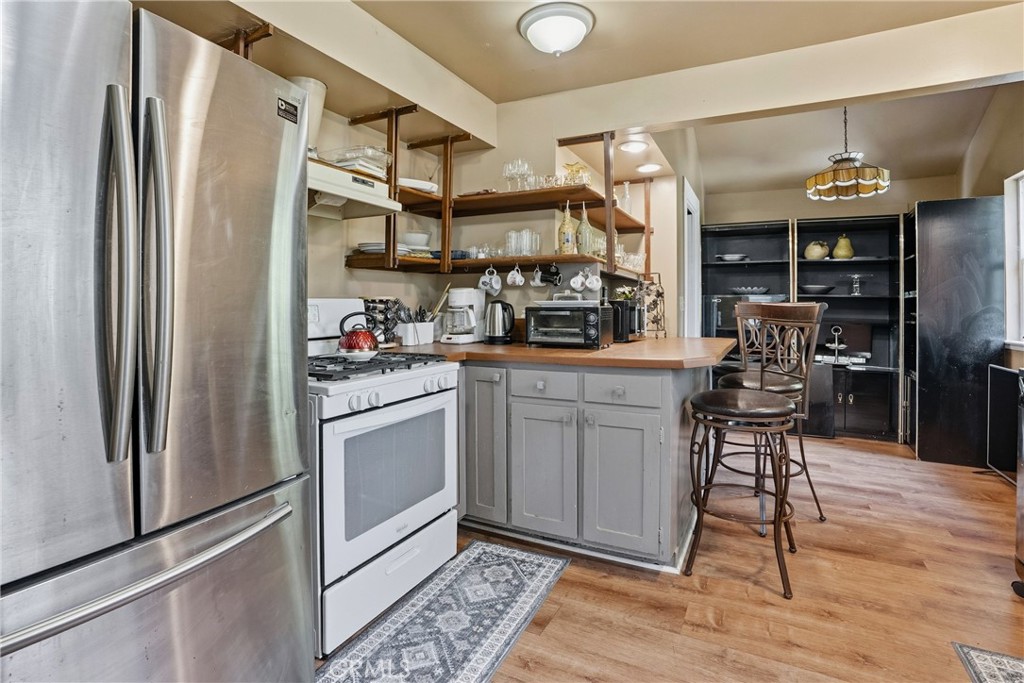 6701 East Zayante Road Felton, CA 95018 - Photo 38 of 44 a kitchen with stainless steel appliances granite countertop a refrigerator a stove and a sink with wooden floor