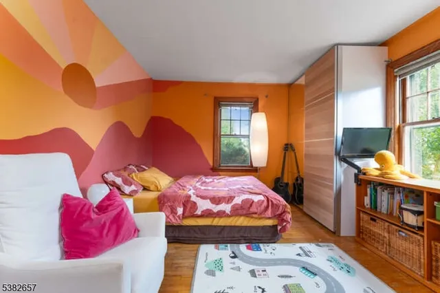 a bedroom with two beds next to a window