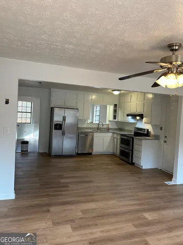 a large kitchen with a refrigerator and a stove