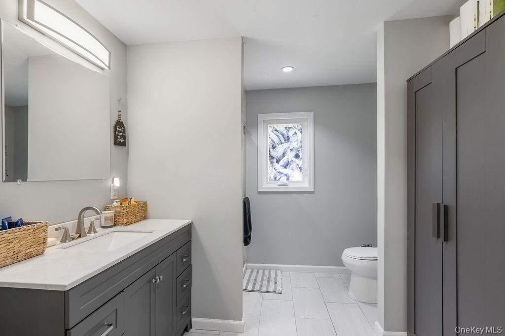 30 Lone Oak Path Smithtown, NY 11787 - Photo 29 of 39 a bathroom with a sink toilet and vanity