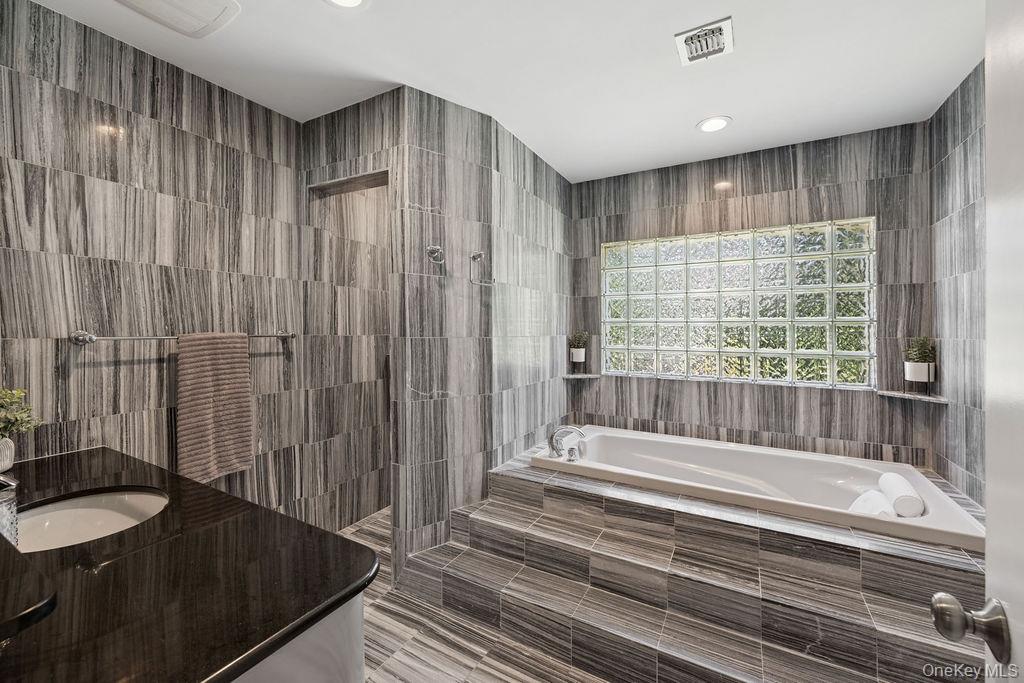 30 Lone Oak Path Smithtown, NY 11787 - Photo 31 of 39 a bathroom with a granite countertop tub sink and shower