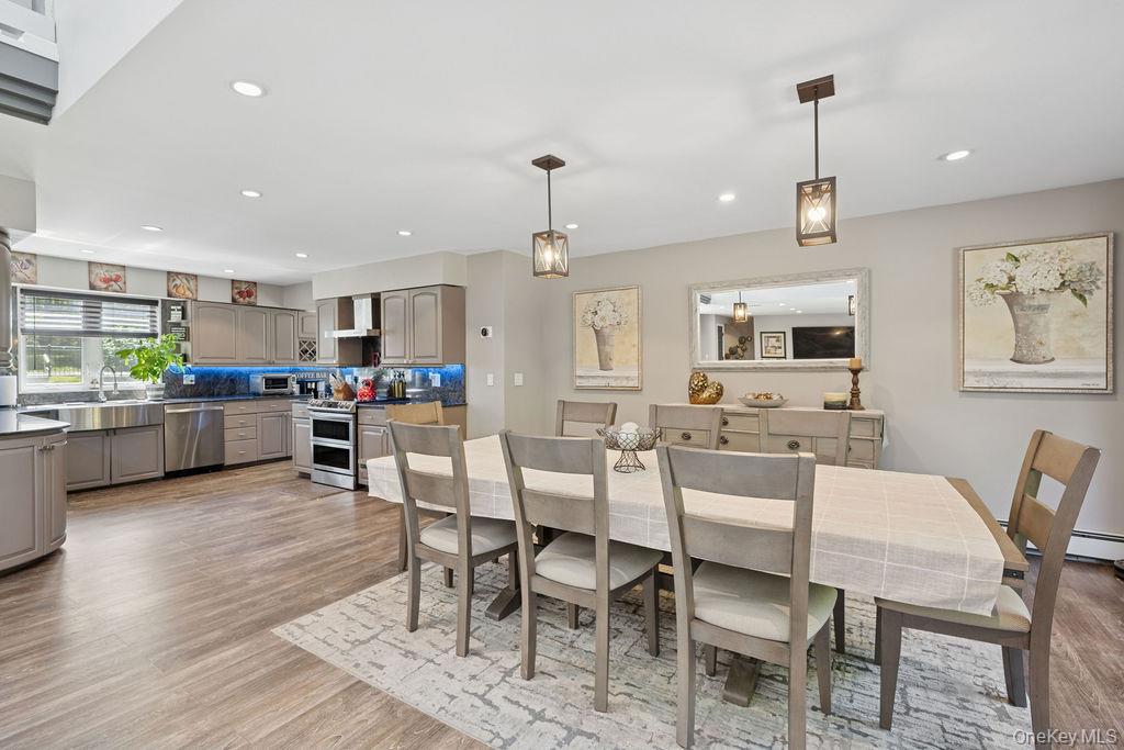 30 Lone Oak Path Smithtown, NY 11787 - Photo 7 of 39 a kitchen with stainless steel appliances kitchen island granite countertop a dining table chairs and sink