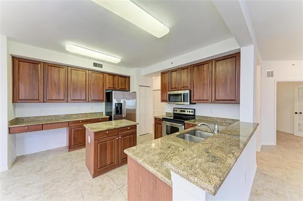 a kitchen with stainless steel appliances granite countertop a stove top oven a refrigerator a sink and dishwasher