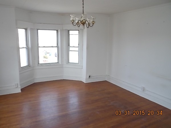 77 Langley Street Fall River, MA 02720 - Photo 8 of 10 an empty room with wooden floor and windows