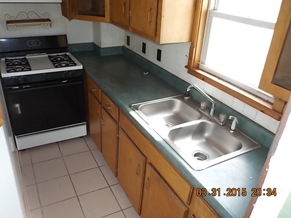 77 Langley Street Fall River, MA 02720 - Photo 9 of 10 a kitchen with a sink and a stove next to a window