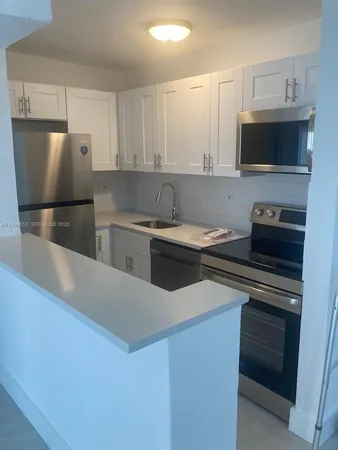 a kitchen with stainless steel appliances a stove a microwave and a refrigerator