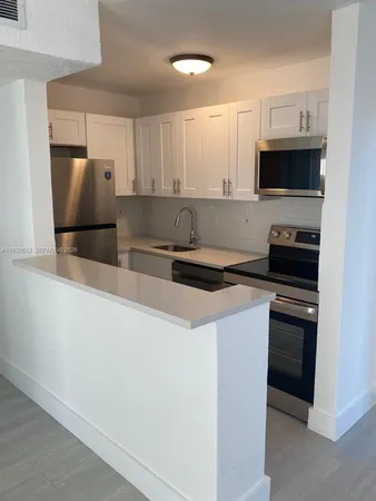 a kitchen with stainless steel appliances a stove microwave and sink