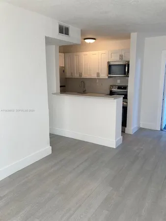 a view of kitchen with stainless steel appliances refrigerator stove microwave and cabinets