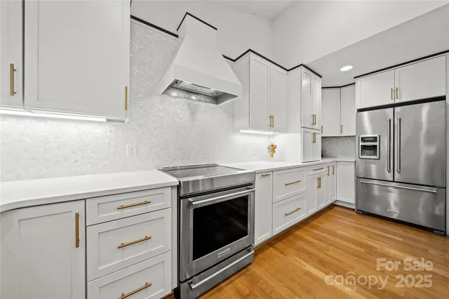 a kitchen with cabinets stainless steel appliances and a counter space
