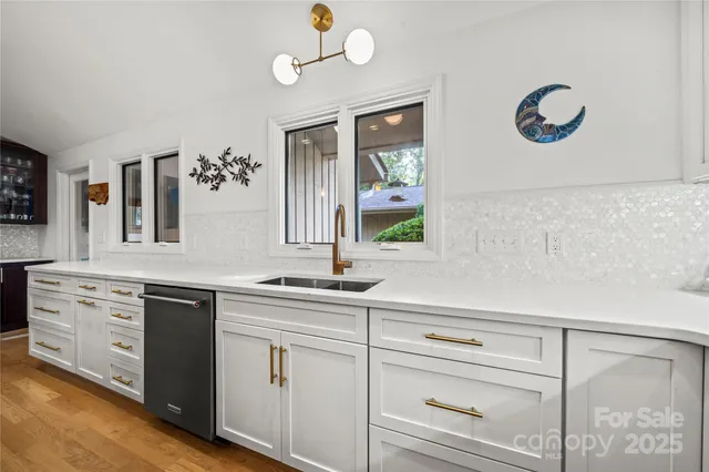a kitchen with white cabinets and sink