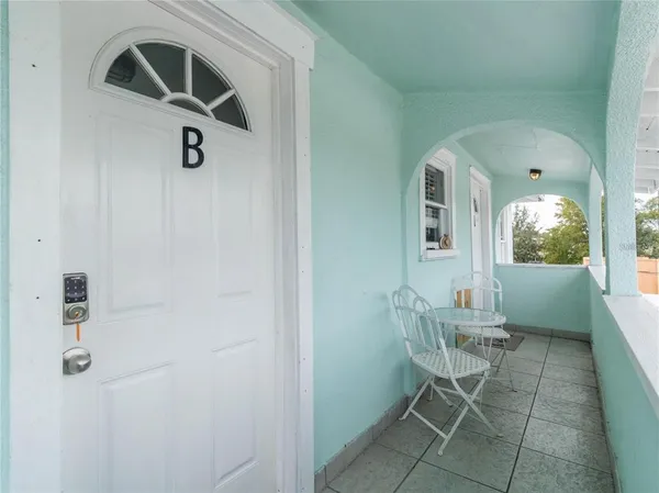 a view of a hallway with wooden floor and a bathroom