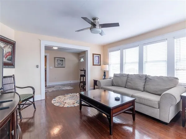 a living room with furniture a ceiling fan and a window